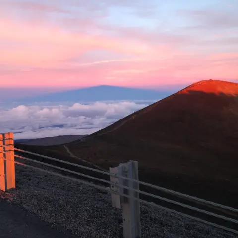 a bench in front of a sunset