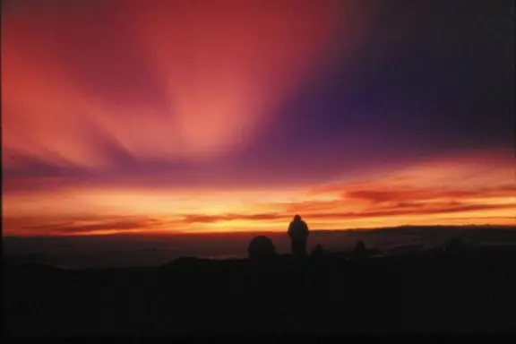 a person standing in front of a sunset