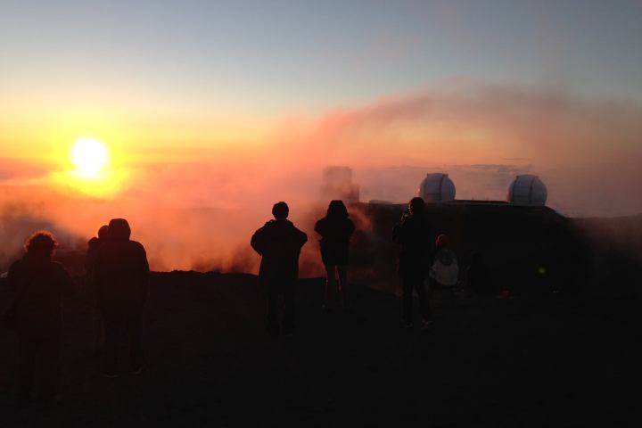 a man standing in front of a sunset