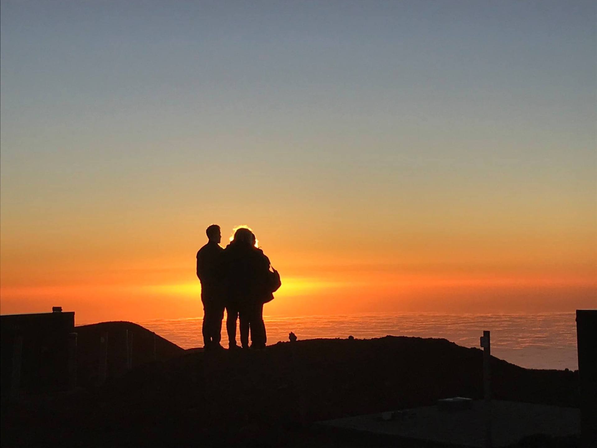 a person standing in front of a sunset
