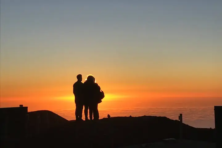 a person standing in front of a sunset