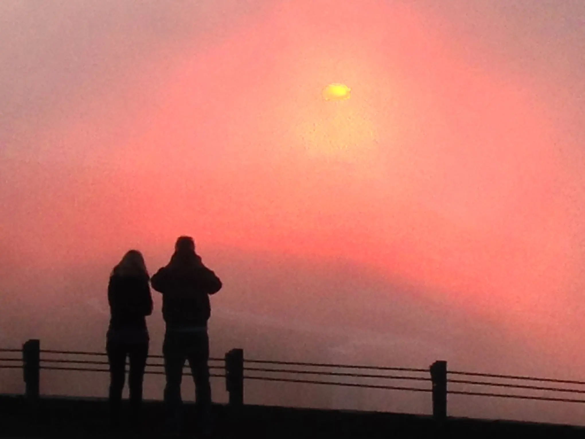 a person standing in front of a sunset